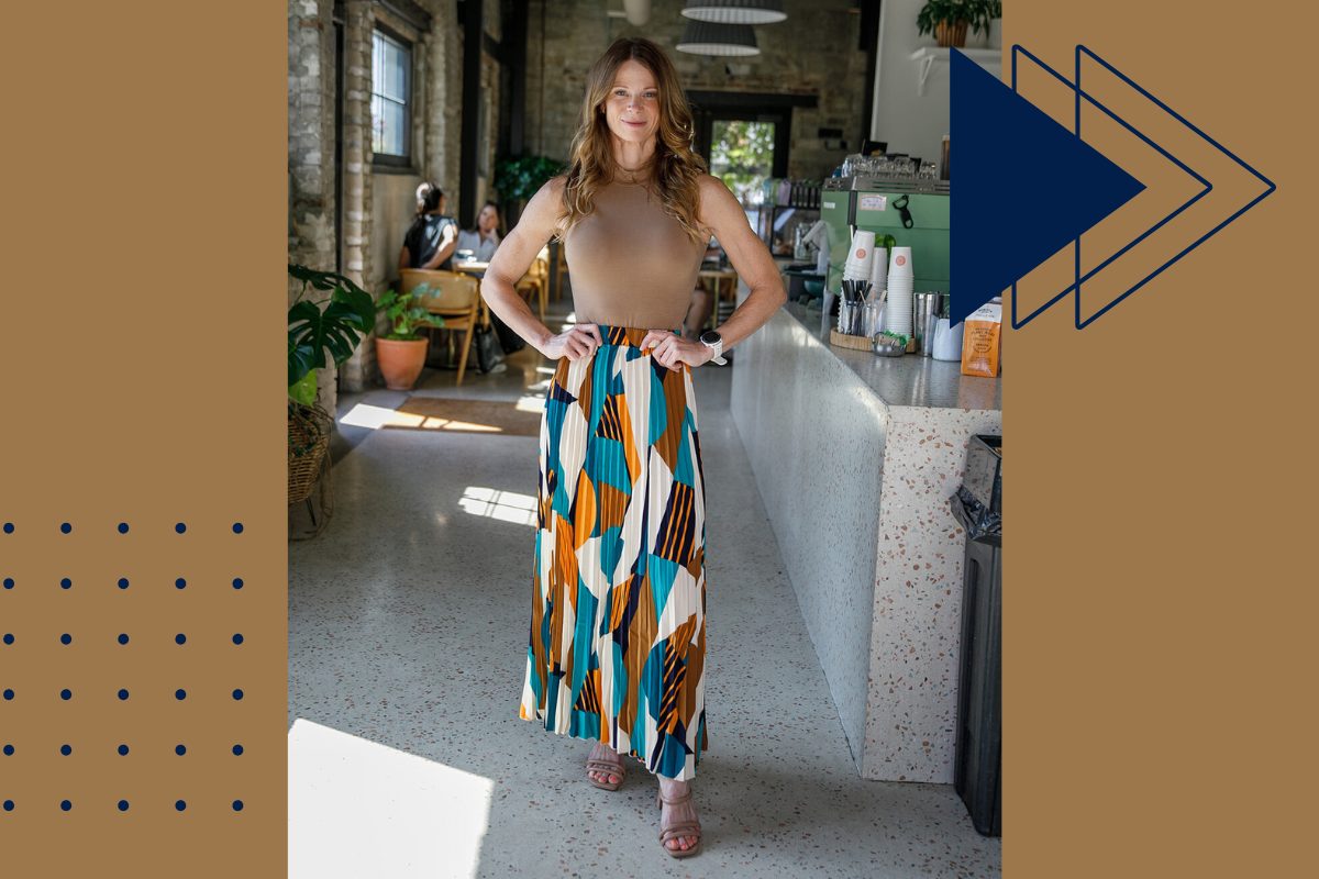 Real estate agent standing confidently in a bright, modern coffee shop—representing friendly, expert support for buying a home in FishHawk Ranch.