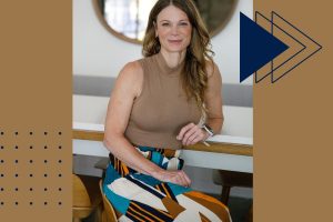 Real estate agent seated at a modern kitchen island, smiling confidently—representing professional guidance for selling your home in FishHawk Ranch